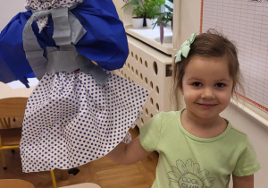 Dziewczynka prezentuje wykonaną Marzannę.
