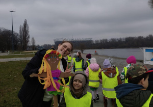 Chłopiec pozuje z Marzanną na tle Wisły.