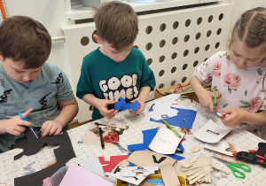 Dzieci wycinają z pianek ubrania dla kukiełek.