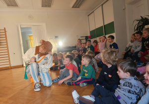 Grupa dzieci bierze udział w warsztatach teatrlnych.