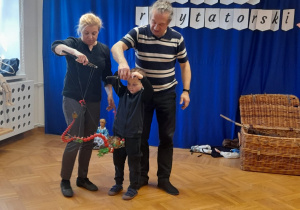 Chłopiec uczy się posługiwać lalką teatralną podczas warsztatów teatralnych.