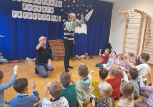 Aktorzy prowadzący warsztaty prezentują sposób poruszania pacynką.