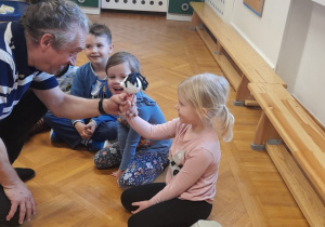 Aktor pokazuje dziewczynce lalkę teatralną.