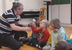 Chłopiec uczy się posługiwać lalką teatralną.