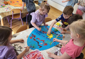 Praca zbiorowa. Dzieci malując farbami ozdabiają jajo z brystolu wg własnego pomysłu.