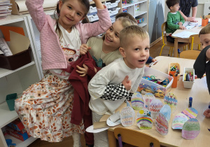 Dzieci prezentują ozdobione przez siebie papierowe jajka.