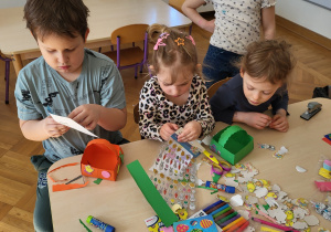 Dzieci wykonują i ozdabiają koszyczki z papieru.