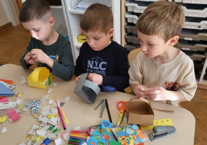 Dzieci wykonują i ozdabiają koszyczki z papieru.