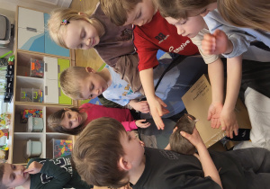 Chłopiec pokazuje szczurka dzieciom.